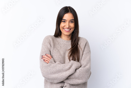 Young brunette woman over isolated white background keeping the arms crossed in frontal position