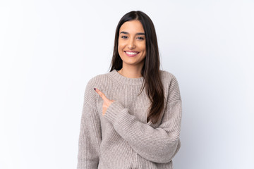Young brunette woman over isolated white background pointing to the side to present a product