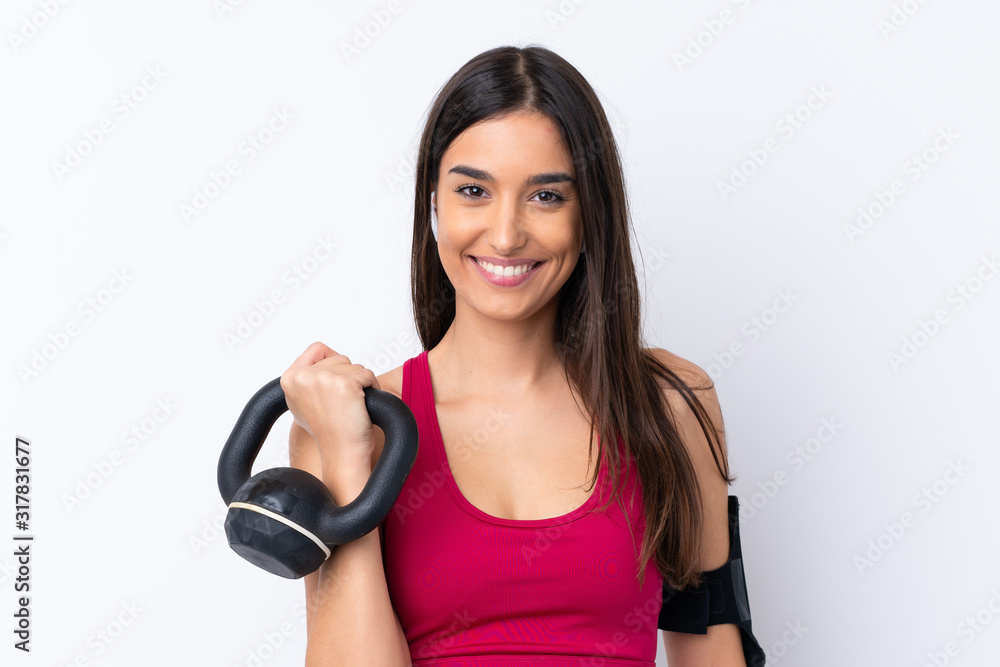 Young sport brunette woman over isolated white background making weightlifting with kettlebell Young sport brunette woman over isolated white background making weightlifting with kettlebell