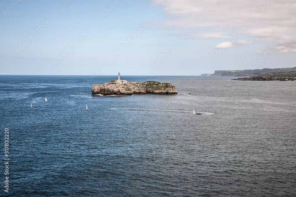 Landscape of a small island with a lighthouse in Cantabria, Spain. Image.