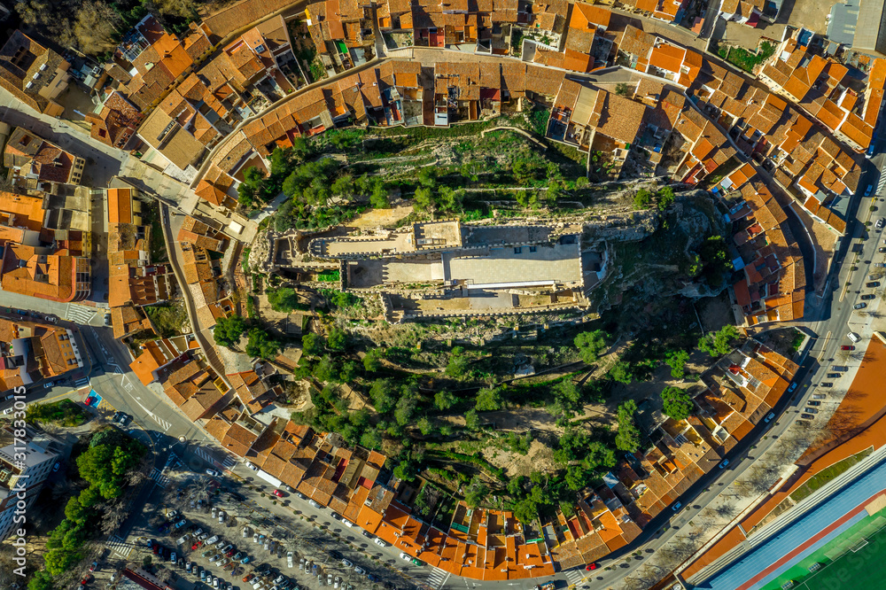 Fototapeta premium Aerial view of medieval Almansa castle with donjon and courtyard on a rock emerging from the plateau surrounded by a circular ring of red roof houses in Spain, site a famous battle