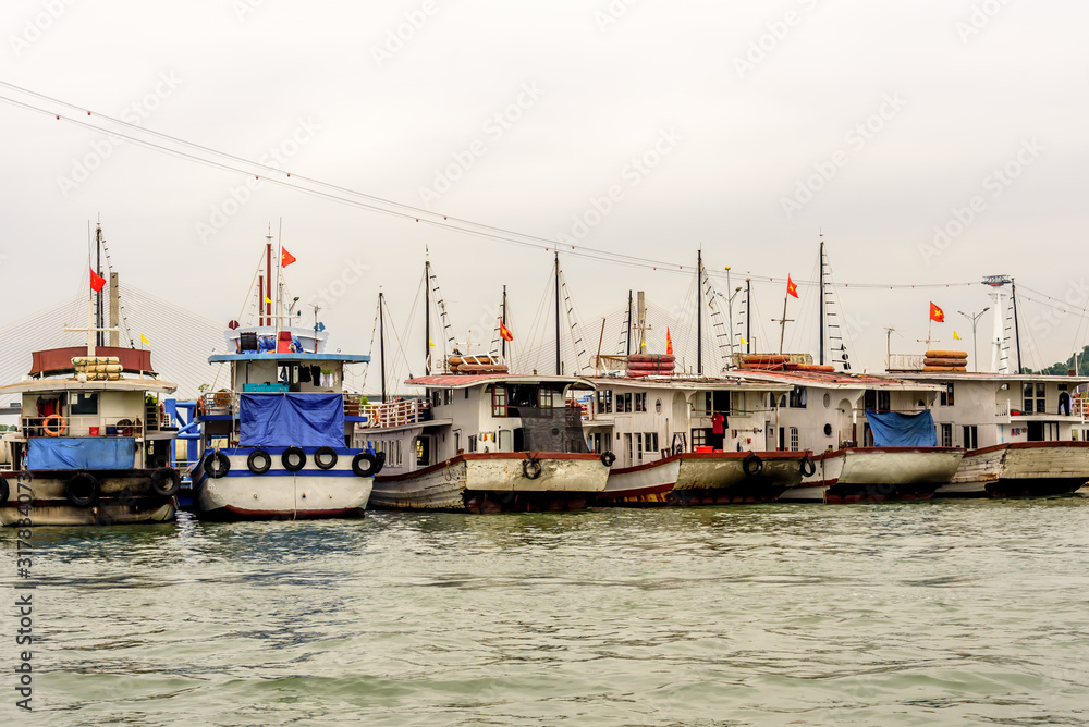 Six Sterns of Traditional Vietnamese Halong Bay Square Head House Boats at a Marine in Halong Bay Vietnam Flying the Vietnamese Flag