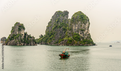 Obraz na plátně Traditional Vietnamese Sailing Fishing Boat in Bai Tu Long Bay in Halong Bay Vie