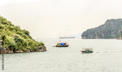 Traditional Vietnamese Sailing Fishing Boat in Bai Tu Long Bay in Halong Bay Vietnam on a Cloudy Day © Mark