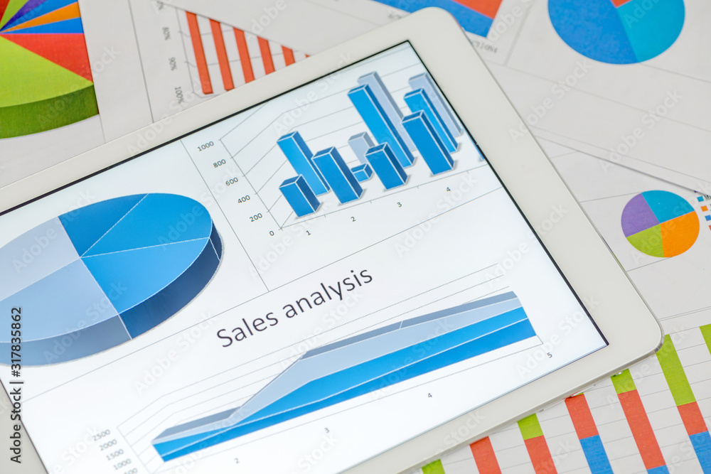 Financial charts on the table with tablet Financial charts on the table with tablet
