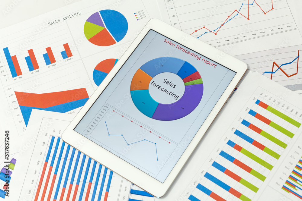 Financial charts on the table with tablet Financial charts on the table with tablet