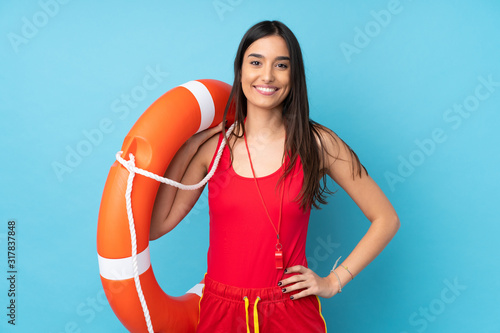 Foto Lifeguard woman over isolated blue background with lifeguard equipment and with