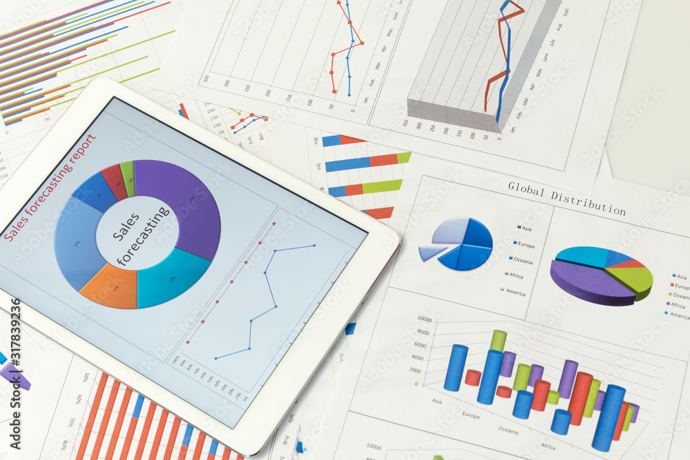 Financial charts on the table with tablet Financial charts on the table with tablet