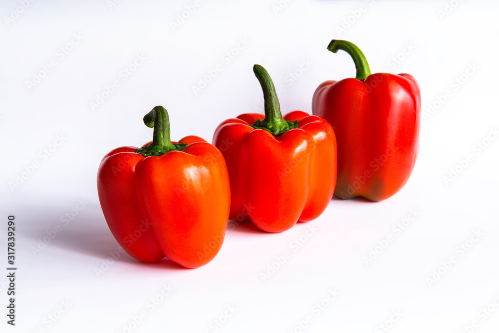 Three red sweet bell peppers, paprika on white background Three red sweet bell peppers, paprika on white background