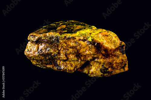uranium mineral isolated on black background. Highly radioactive and dangerous ore.