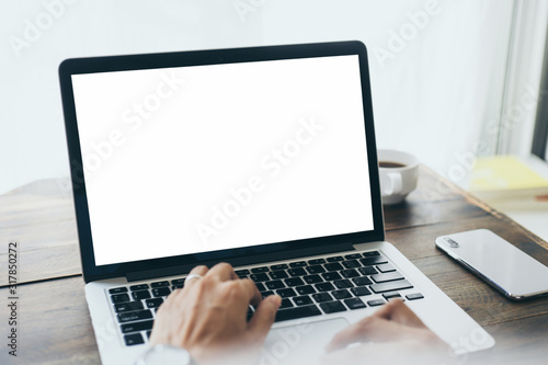 mockup image blank screen computer with blank white background for advertising text,hand man using laptop contact business search information on desk at home office.marketing and creative des