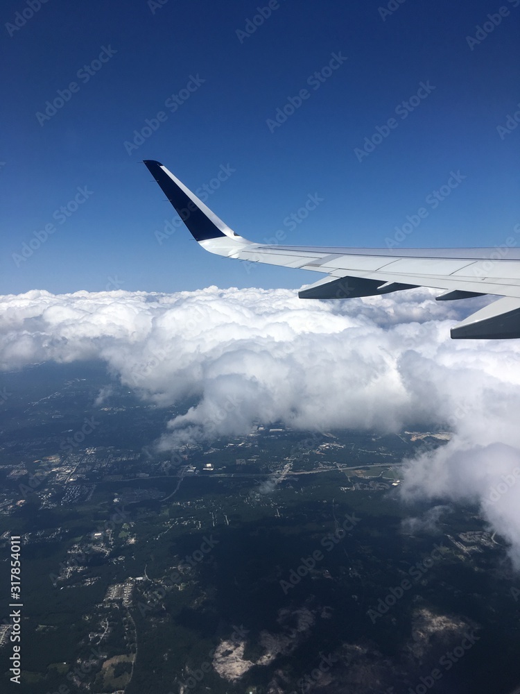 wing of an airplane flying above the clouds wing of an airplane flying above the clouds