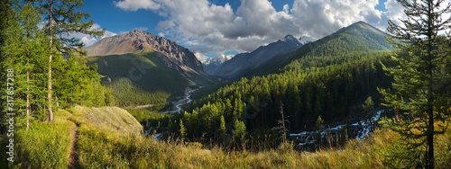 Panoramic mountain view. Two valleys with rivers  forested slopes  snow-capped peaks. Travel and vacation in the mountains.