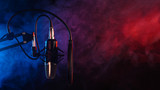 Close up studio condenser microphone on stand and anti-vibration mount. Live recording with colored lights background. Side view.Red blue disco light.Karaoke