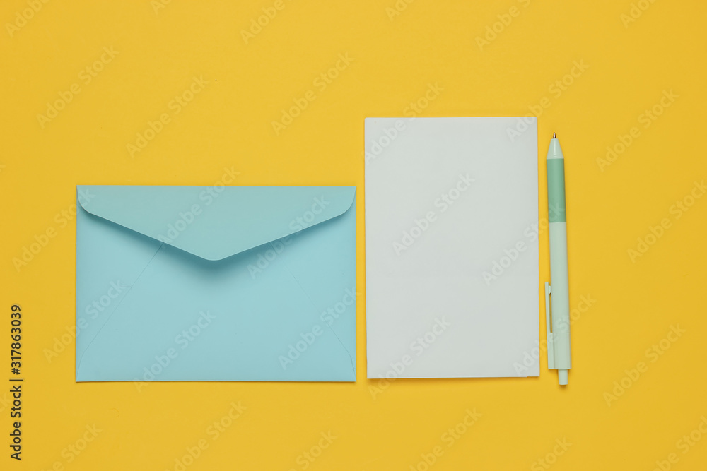 Envelope with a letter and pen on yellow background. Valentine's day, wedding or birthday. Top view Envelope with a letter and pen on yellow background. Valentine's day, wedding or birthday. Top view
