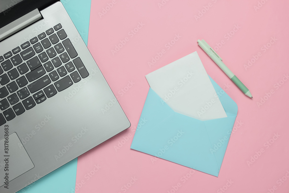 Laptop and envelope with letter on pink blue pastel background. Valentine's day. Top view Laptop and envelope with letter on pink blue pastel background. Valentine's day. Top view