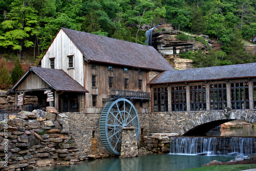 Canvas Print Old mill on the river with a water falls in the background