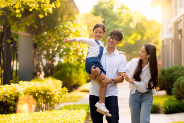 Asian family walking together in the village gardent