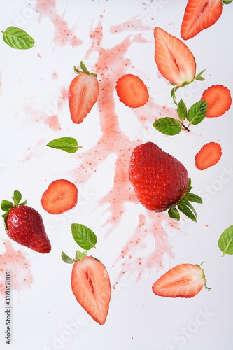 Fototapeta Naklejka Na Ścianę i Meble -  Flying fresh strawberries with mint leaves at white background. Food levitation concept. Creative food layout
