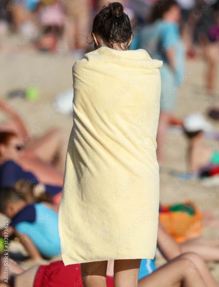Girl in a yellow towel on the seashore