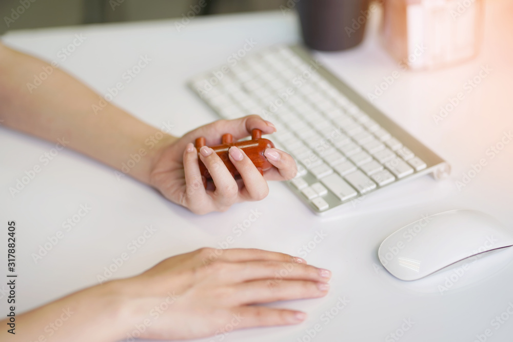 Office woman using massage stick for Stimulate circulation, decrease muscle pain and tension hands and fingers to sooth the strain caused by using keyboards,smartphones.Health care concept Office woman using massage stick for Stimulate circulation, decrease muscle pain and tension hands and fingers to sooth the strain caused by using keyboards,smartphones.Health care concept