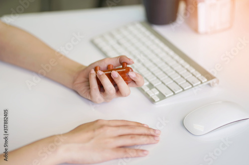 Office woman using massage stick for Stimulate circulation  decrease muscle pain and tension hands and fingers to sooth the strain caused by using keyboards smartphones.Health care concept