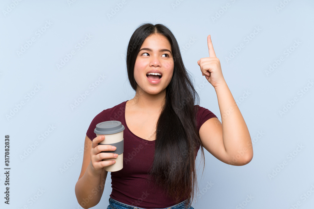 Young teenager Asian girl holding a take away coffee intending to realizes the solution while lifting a finger up Young teenager Asian girl holding a take away coffee intending to realizes the solution while lifting a finger up