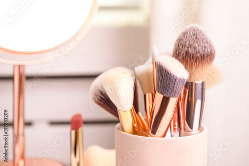 Set of professional makeup brushes in holder, closeup photo