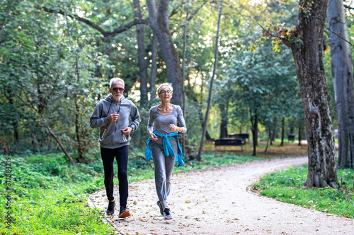 Mature couple man and woman jogging in the park