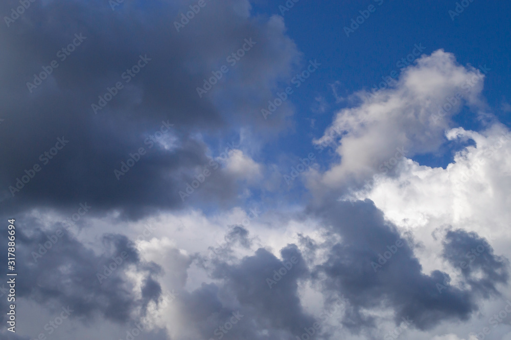 Grey cumulus clouds on blue sky before rain.