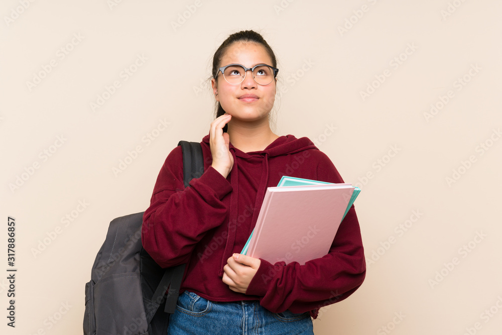 Fototapeta premium Young student Asian girl woman over isolated background thinking an idea