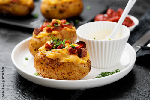 Hot baked potato topped with bacon, green onions and sun dried tomatoes.