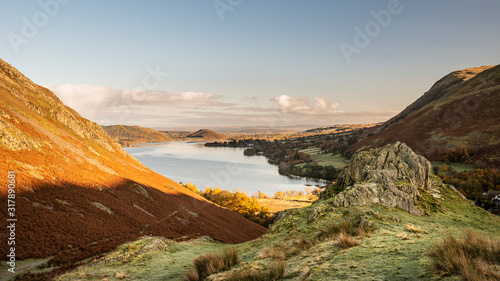 Beautiful Autumn Fall landscape of Ullswater and surrounding mountains and hills viewed from Hallin Fell on a crisp cold morning with majestic sunlgiht on the hillsides © veneratio