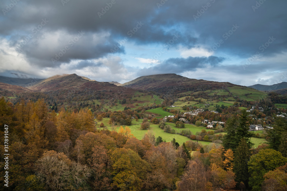 Autumn Fall landscape view from Loughrigg Brow over Keswick towards mountain background with dramatic sky