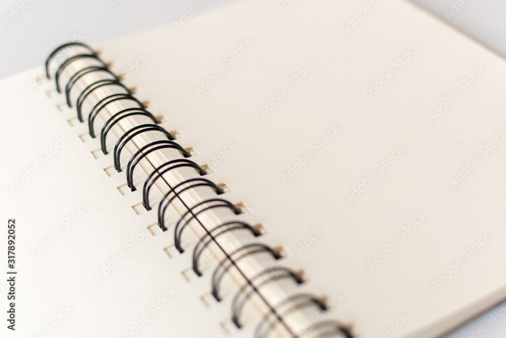 Close up shot of an open blank sketchbook placed on a light gray table. Close up shot of an open blank sketchbook placed on a light gray table.
