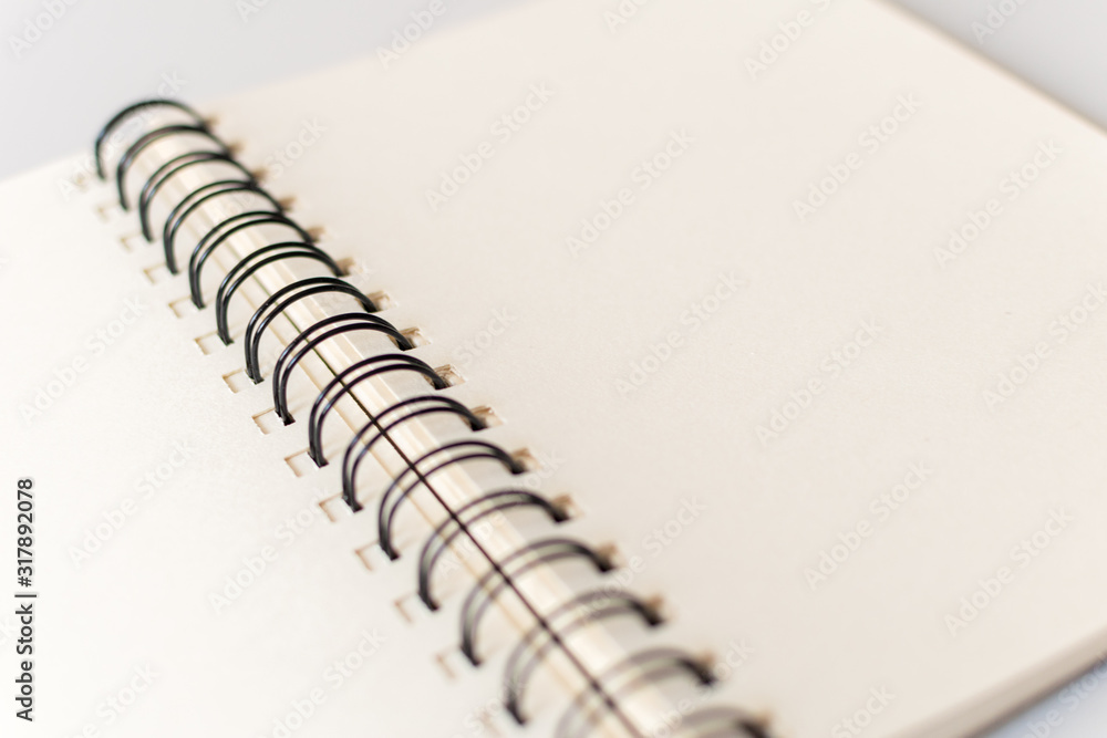 Close up shot of an open blank sketchbook placed on a light gray table. Close up shot of an open blank sketchbook placed on a light gray table.