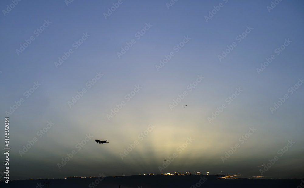 Jet plane landing in sunrise time in front of dramatic sky.
