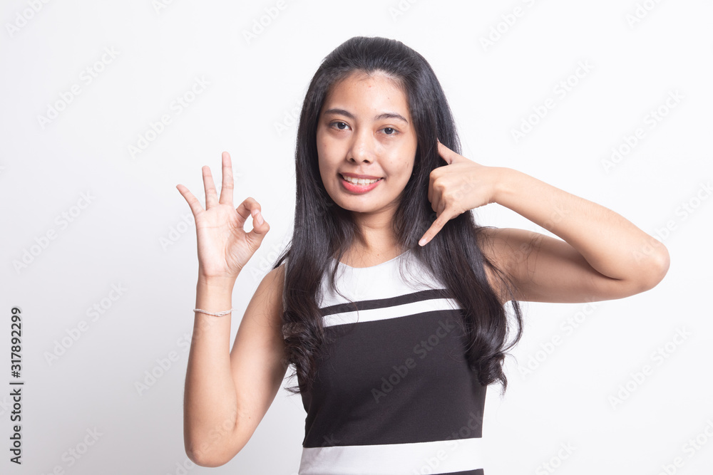 Young Asian woman show with phone gesture and OK sign. Young Asian woman show with phone gesture and OK sign.