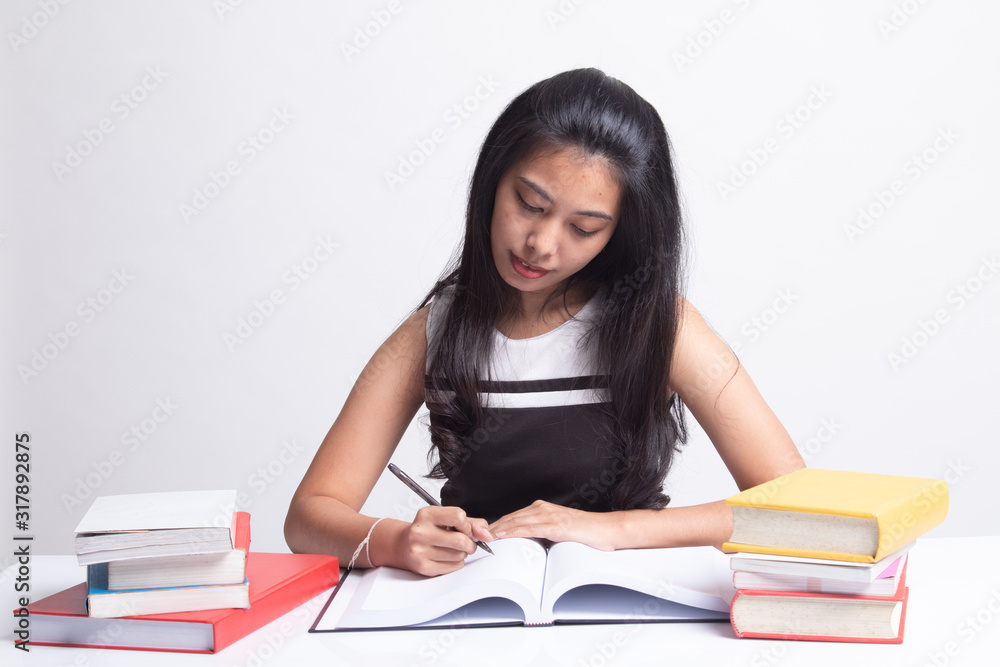 Young Asian woman read a book with books on table. Young Asian woman read a book with books on table.