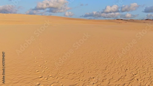 Stunning early morning sunrise aerial drone flight over Wungul Sand Blow, a massive sand dune formed by wind and displacing the natural rain forest on Fraser Island, Queensland, Australia.  photo