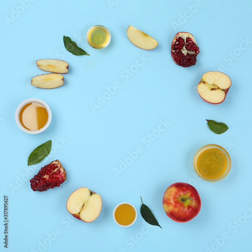 Flat lay composition with honey and fruits on light blue background, space for text. Rosh Hashanah holiday