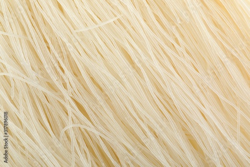 Raw rice noodles as background, closeup view