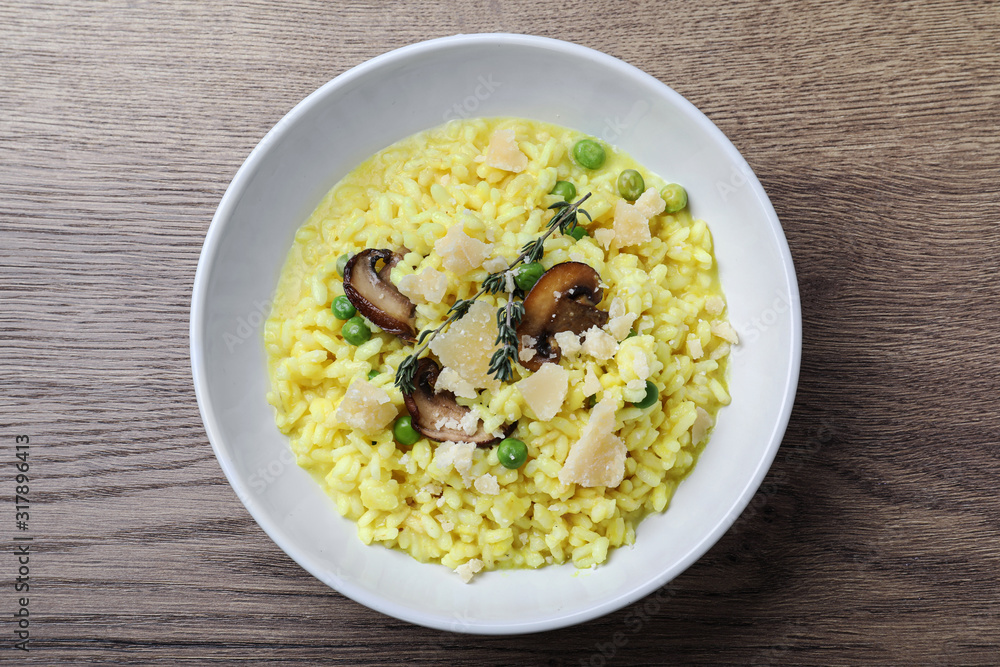 Delicious risotto with cheese and mushrooms on wooden table, top view Delicious risotto with cheese and mushrooms on wooden table, top view