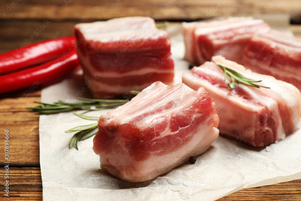 Raw ribs with rosemary on wooden table, closeup Raw ribs with rosemary on wooden table, closeup