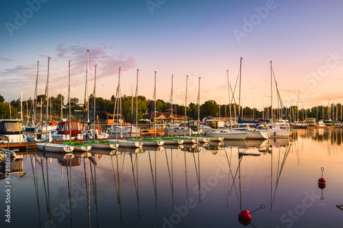 Fototapeta Naklejka Na Ścianę i Meble -  Boats docking in the marina at the Niegocin Lake during sunrise. Wilkasy, Masuria , Poland.