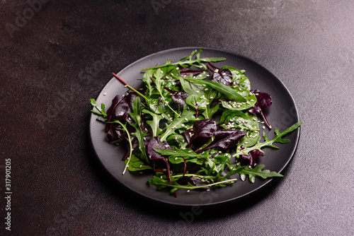 Healthy food, salad mix with arugula, spinach, bulls blood, beet leafs and micro greens