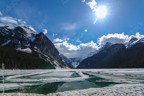 Fototapeta Naklejka Na Ścianę i Meble -  Lake Louise in a beautiful sunny day Mountain wild lake in Rocky Mountains in early spring still frozen with snowy mountains 