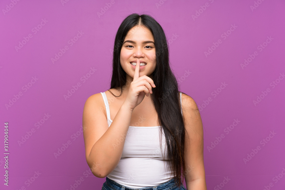 Young teenager Asian girl over isolated purple background doing silence gesture Young teenager Asian girl over isolated purple background doing silence gesture