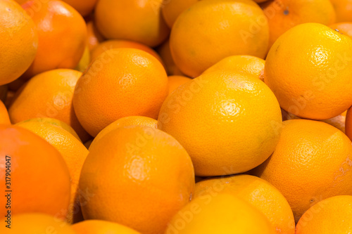 Fresh oranges in the store. Close up view of madarines orange on the sheft in the supermarket. Healty and fresh fruits background in a supermarket super store