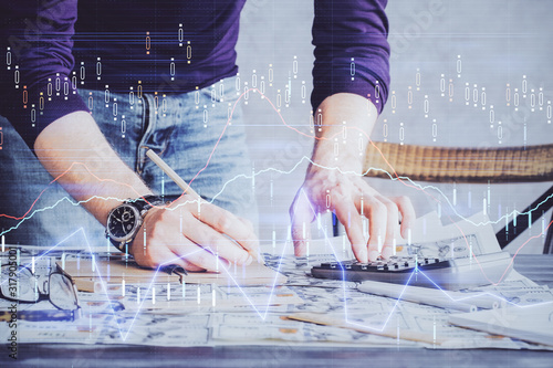 Multi exposure of man standing and planing investment with stock market forex chart.